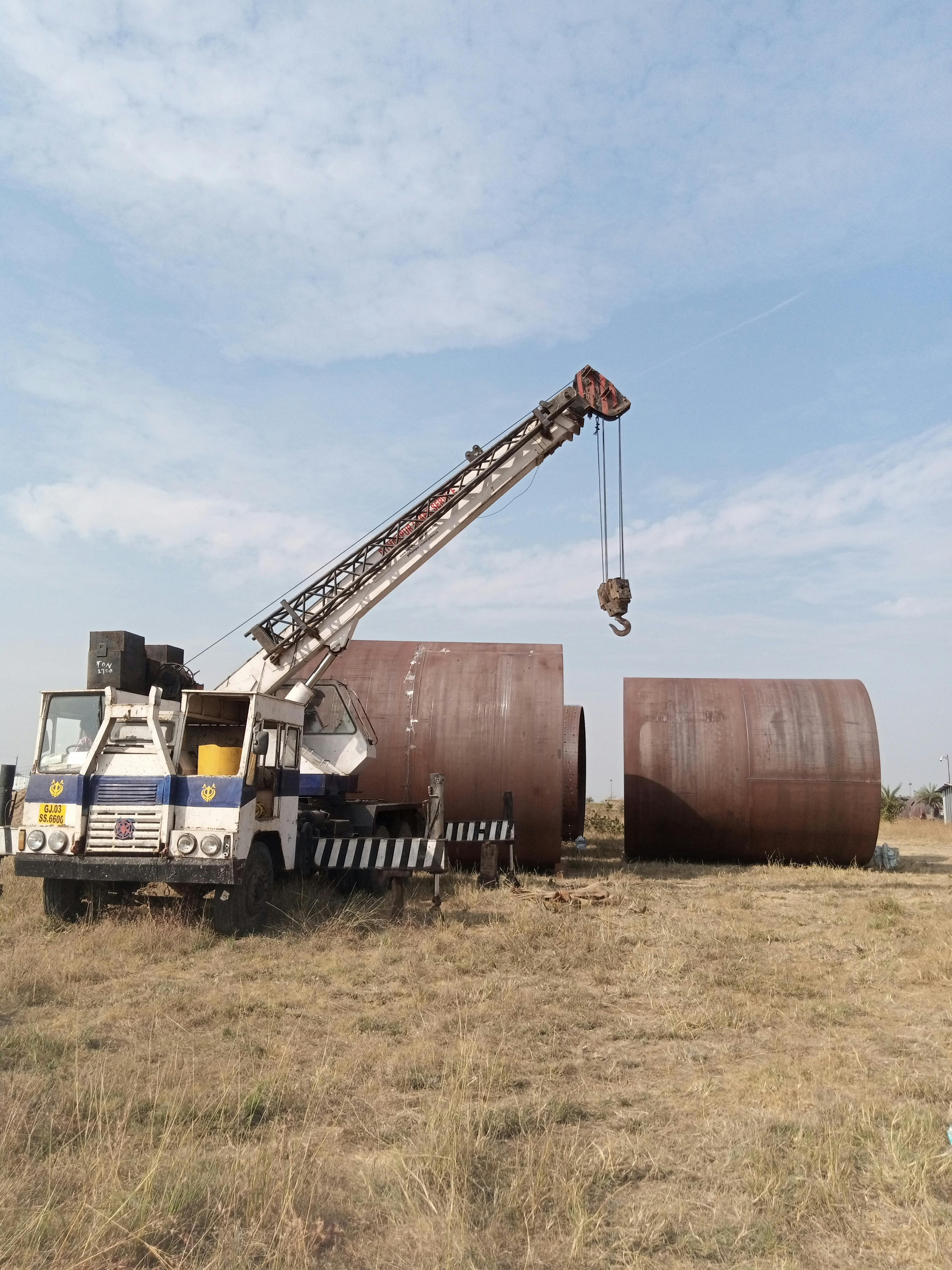 Crane lifting large tanks